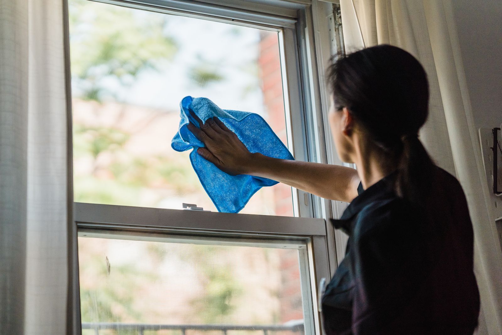 Crew member wiping glass with a blue microfiber cloth