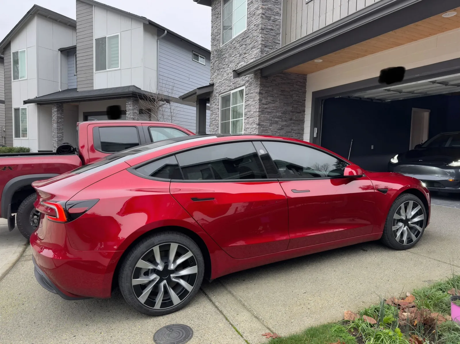 Red electric sedan shining on a driveway