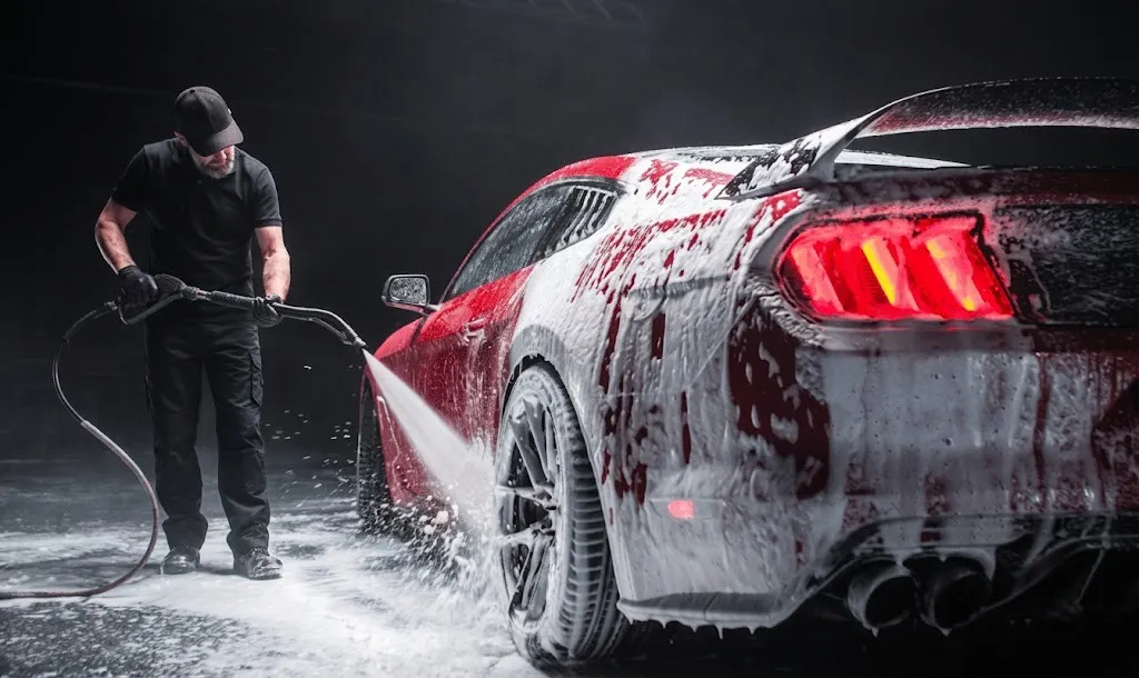 Pressure rinse cutting through thick foam on a red car